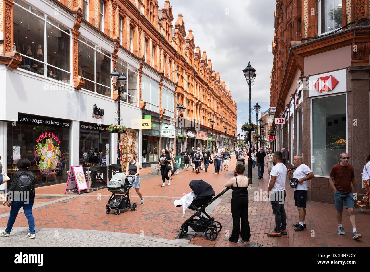 Shopper und Besucher in der Fußgängerzone Queen Victoria Street in Reading, bekannt für ihre barocke Architektur aus dem späten 19. Jahrhundert. England Stockfoto