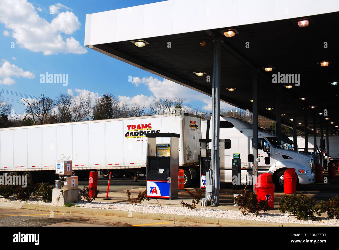 Große Lastwagen fahren an der Tankstelle an, um an einer LKW-Haltestelle und einem Rastplatz gleich neben dem interstate Highway zu tanken Stockfoto
