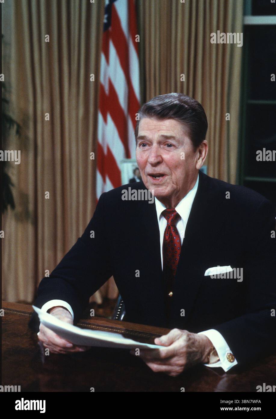 US-Präsident Ronald Reagan posiert für Fotos, nachdem er am Dienstag, den 2. Februar, im Oval Office des Weißen Hauses in Washington, DC, USA, eine landesweit im Fernsehen übertragene Ansprache an die Nation über Hilfe für den Nicaraguanischen Demokratischen Widerstand (Contras) gehalten hat. 1988. Vermerk: Ron Sachs/CNP Stockfoto