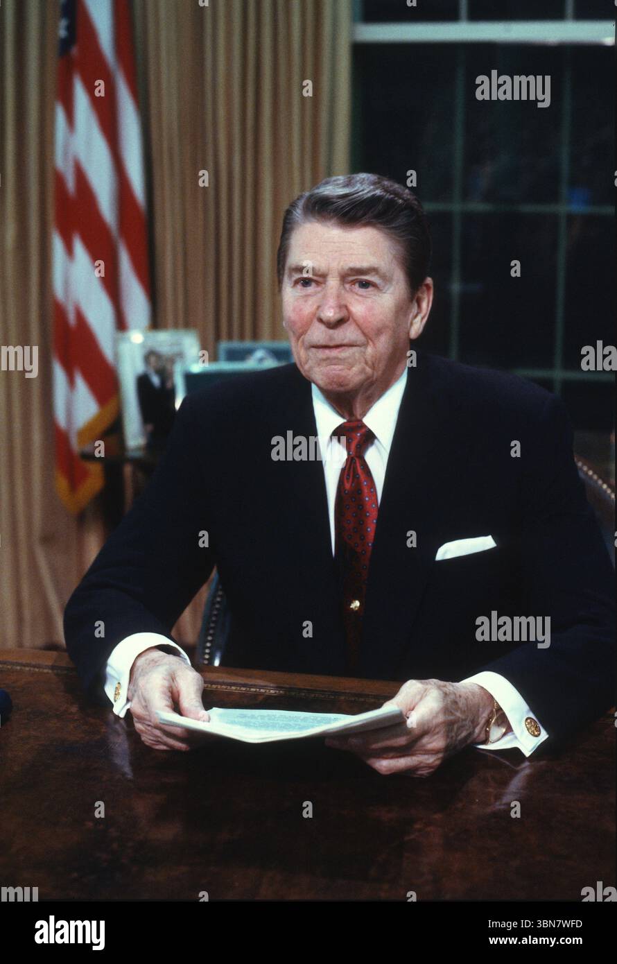 US-Präsident Ronald Reagan posiert für Fotos, nachdem er am Dienstag, den 2. Februar, im Oval Office des Weißen Hauses in Washington, DC, USA, eine landesweit im Fernsehen übertragene Ansprache an die Nation über Hilfe für den Nicaraguanischen Demokratischen Widerstand (Contras) gehalten hat. 1988. Vermerk: Ron Sachs/CNP Stockfoto