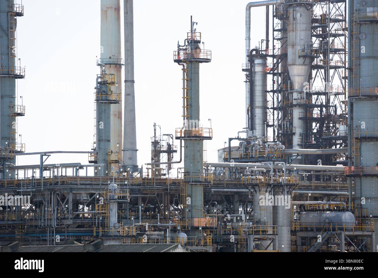 Raffinerienetz mit flachen Destillationssäulen, Rohren, Laufstegen, Ventilen unter hellem Himmel Stockfoto