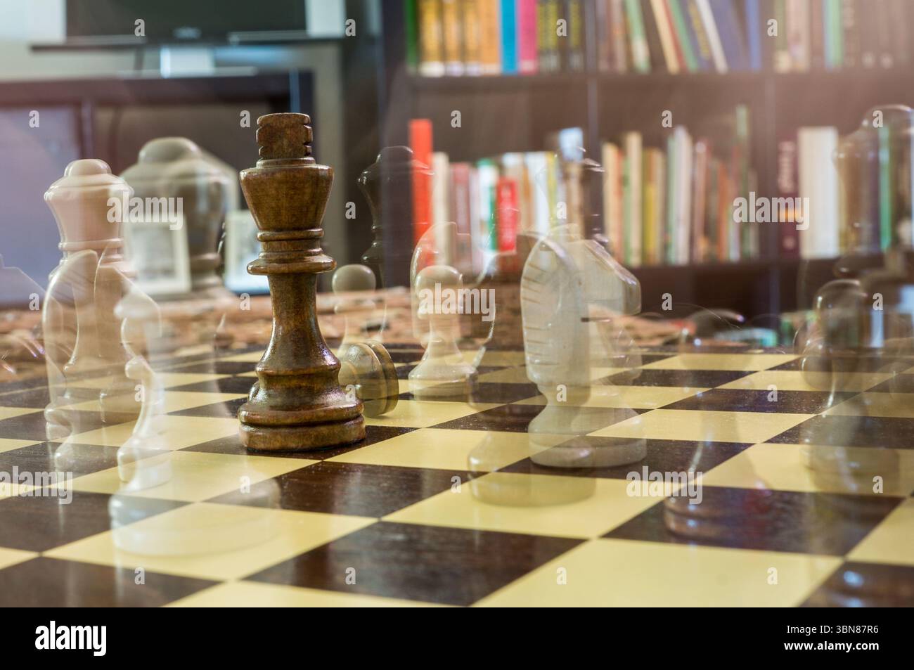 Schachspiel mit dem König im Fokus und den restlichen Figuren im Geistereffekt Stockfoto
