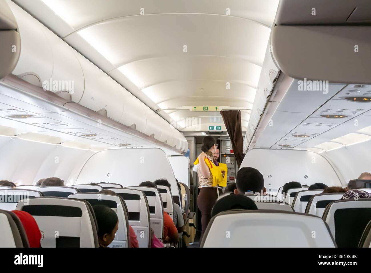 Ein Flugbegleiter, der Fluggästen im Airbus A320 von Etihad Airways eine Rettungsweste vorführt Stockfoto