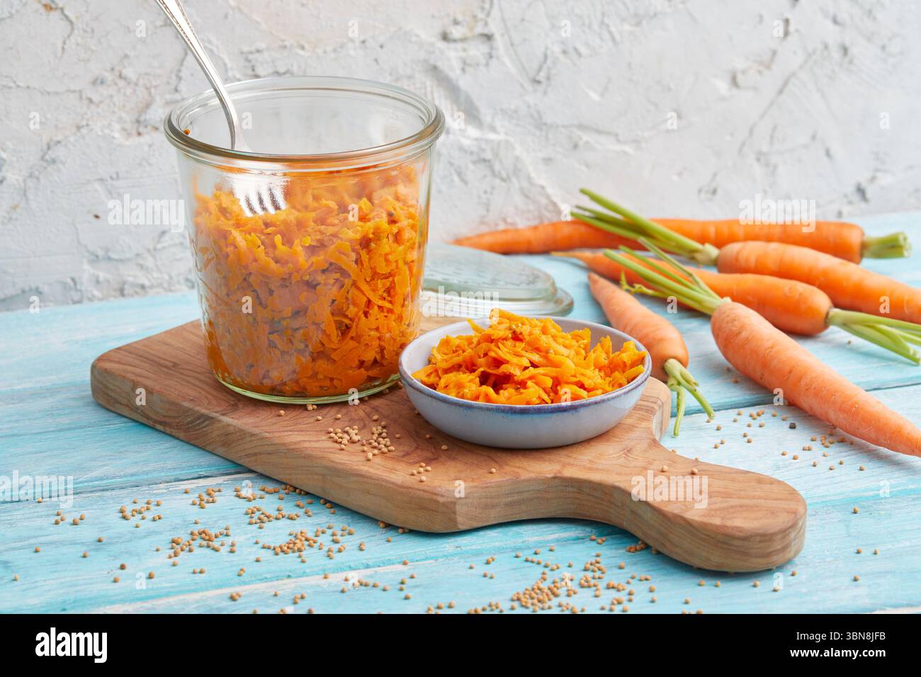 Geriebener Karottensalat in einem Glas – rohe vegane Mahlzeitenzubereitung Stockfoto
