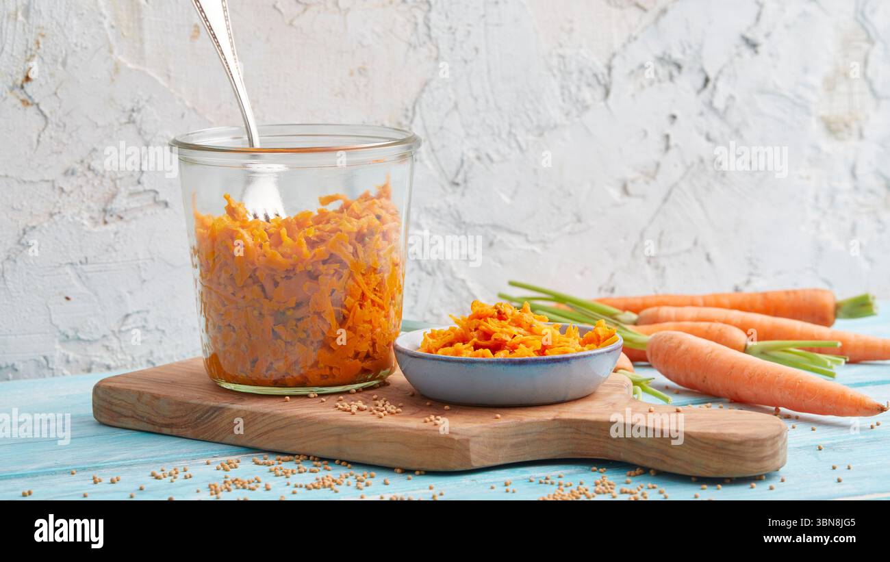 Geriebener Karottensalat in einem Glas – rohe vegane Mahlzeitenzubereitung Stockfoto
