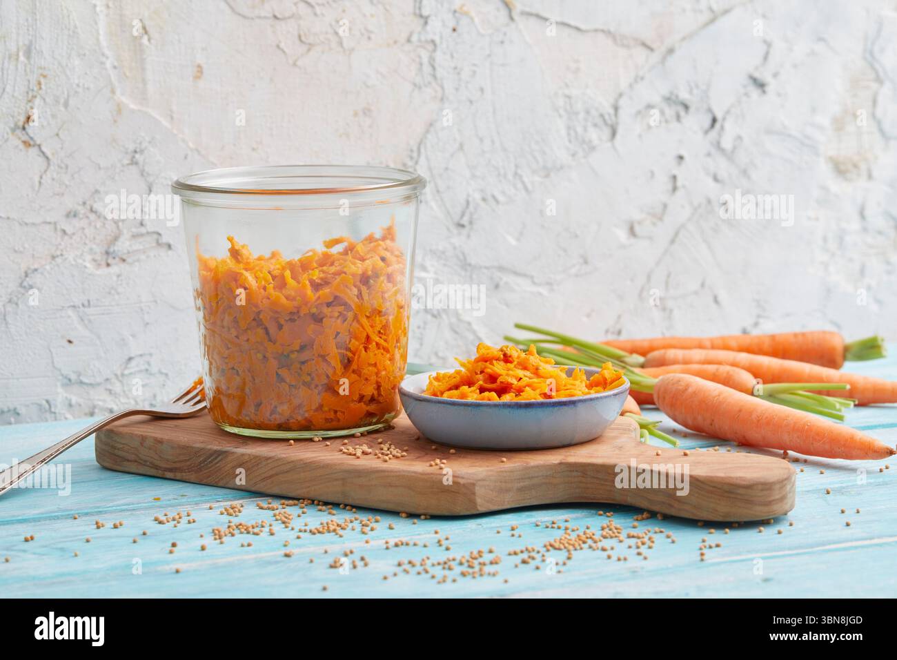 Geriebener Karottensalat in einem Glas – rohe vegane Mahlzeitenzubereitung Stockfoto