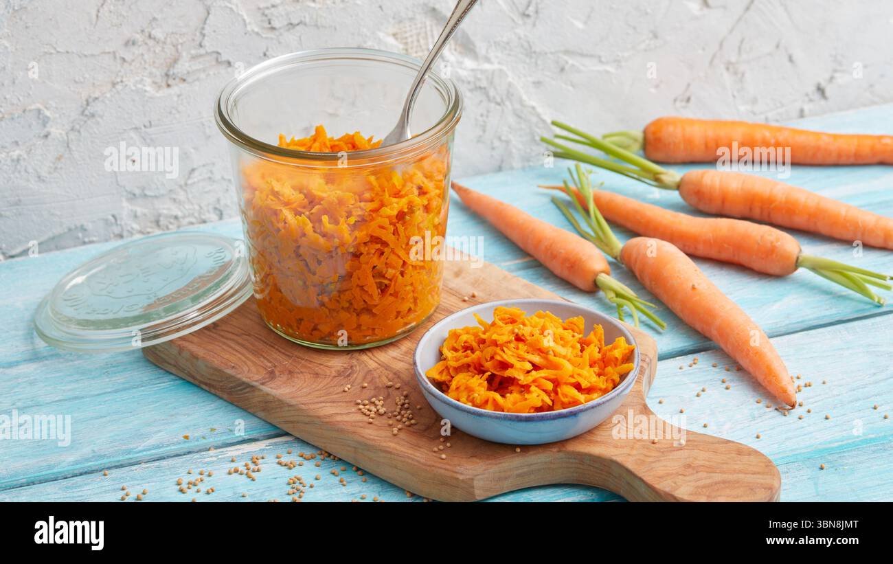 Geriebener Karottensalat in einem Glas – rohe vegane Mahlzeitenzubereitung Stockfoto