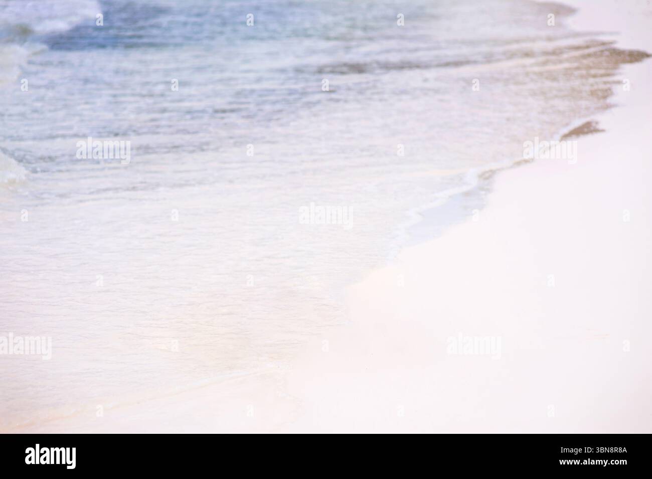 Ruhige Strandwellen plätschern sanft an einem wunderschönen Sandstrand und schaffen Frieden und Ruhe Stockfoto