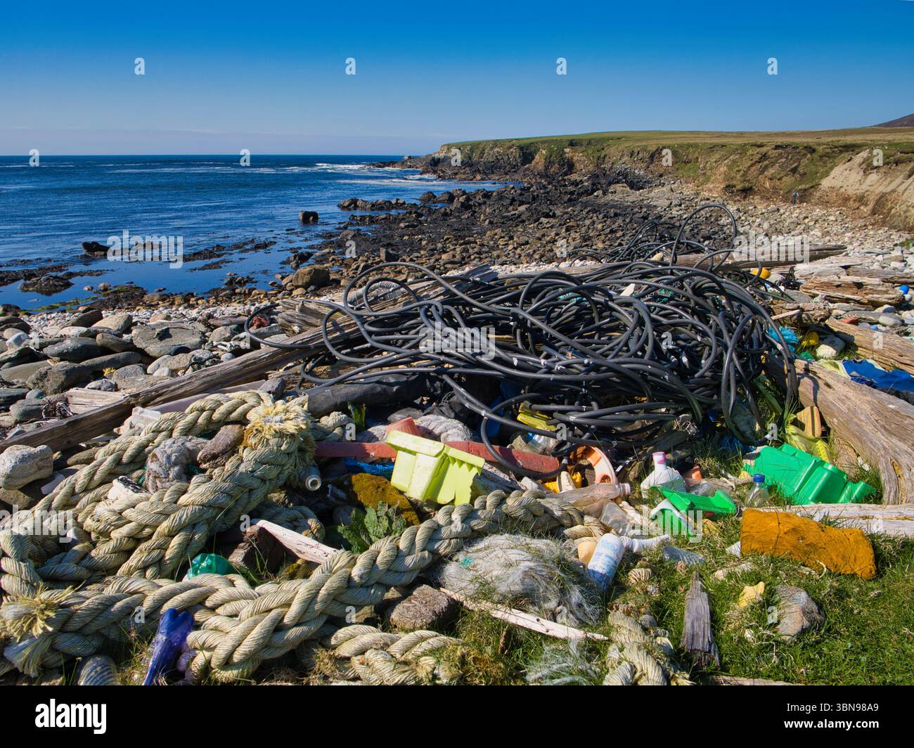 Plastikmüll und Seile verstreuen einen felsigen Strand in Unst, Shetland, was die Umweltverschmutzung hervorhebt Stockfoto