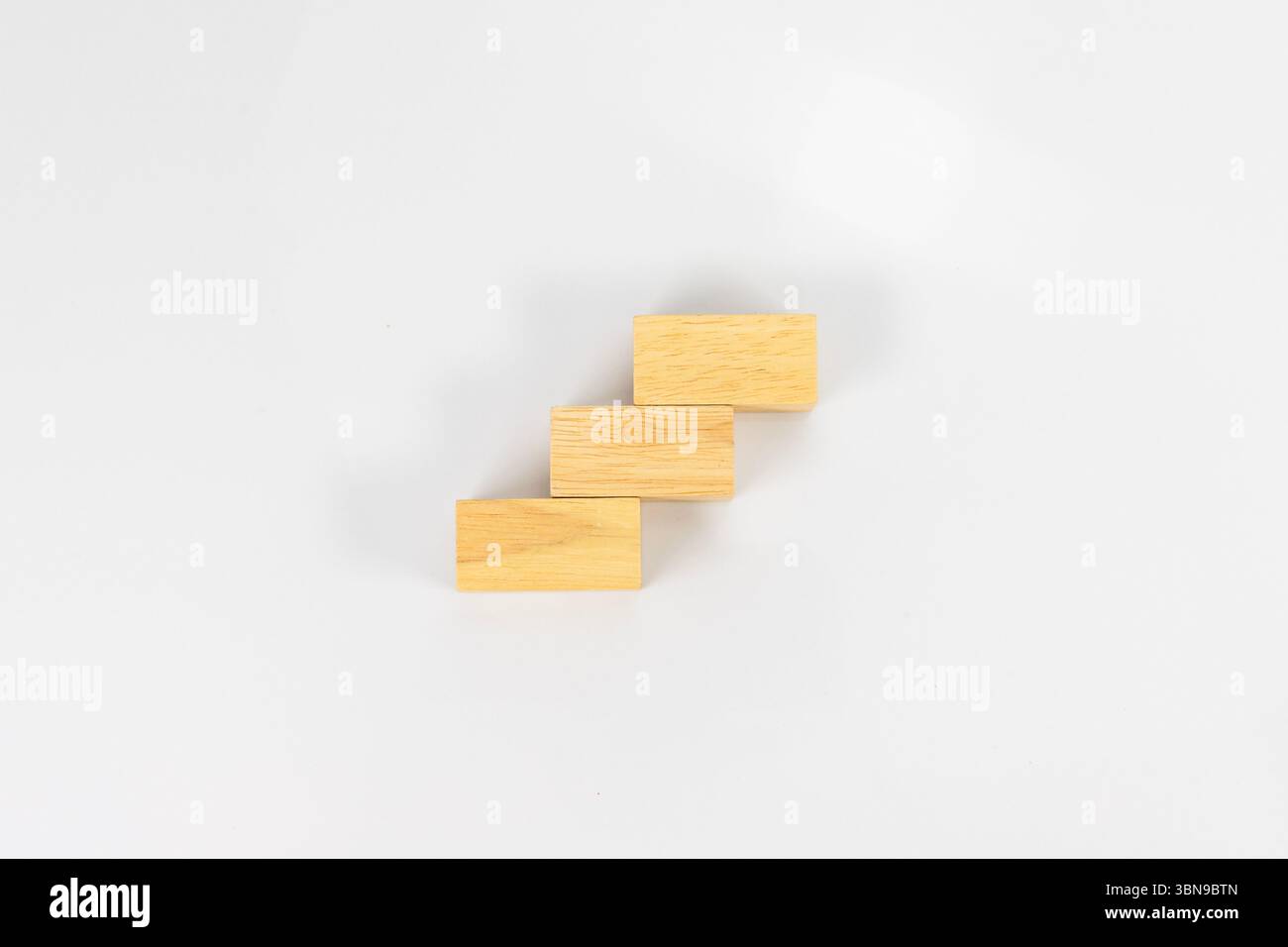Minimalistisches Treppenstufenkonzept aus Holzblöcken auf weißem Hintergrund Stockfoto
