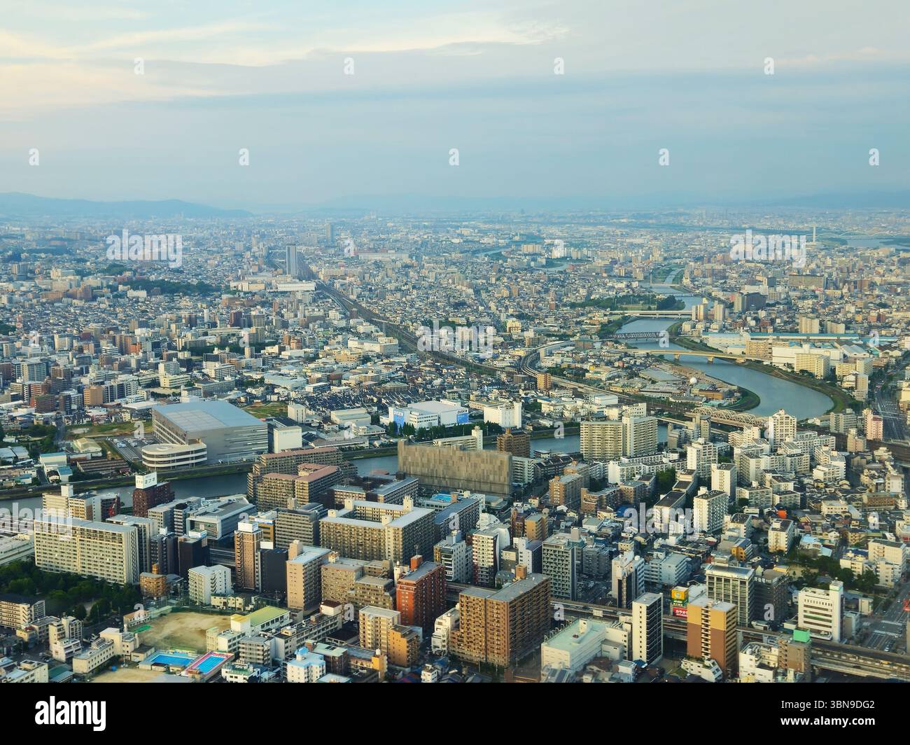 Aus der Vogelperspektive auf Osaka City und den kurvenreichen Kanzaki River in der Abenddämmerung Stockfoto