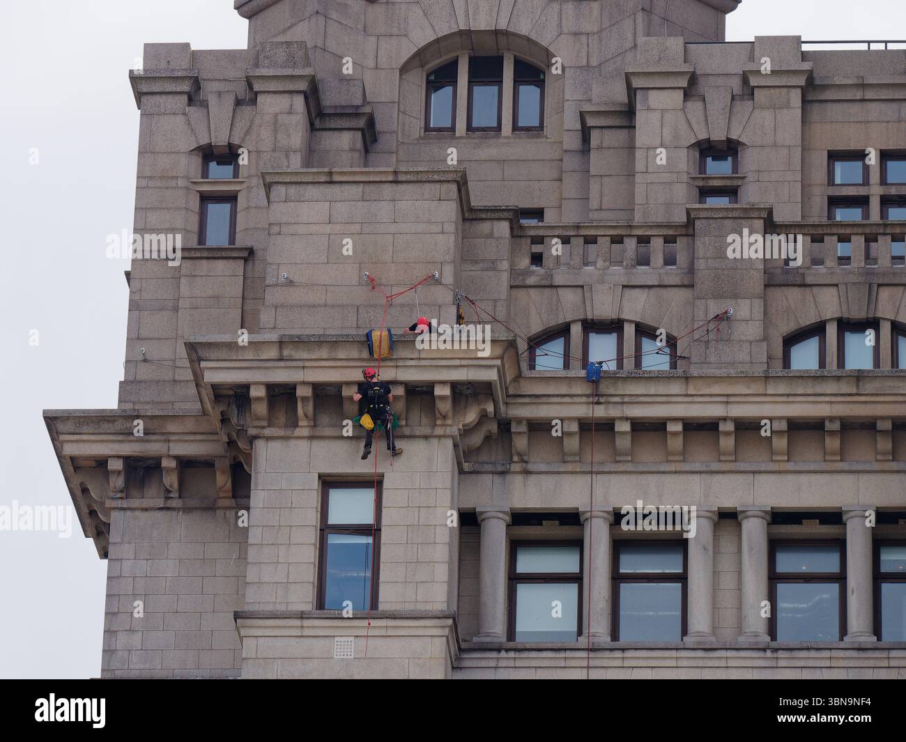 Nahaufnahme des Lebergebäudes mit Seilzugangstechnikern/Arbeitern, die das Exterio pflegen. Liverpool, Merseyside, England. 30. Juni 2025 Stockfoto