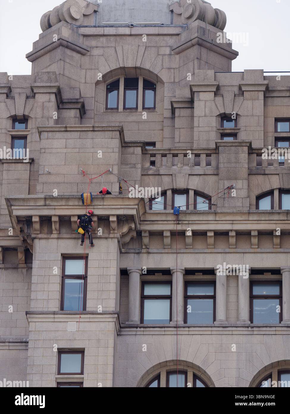 Nahaufnahme des Lebergebäudes mit Seilzugangstechnikern/Arbeitern, die das Exterio pflegen. Liverpool, Merseyside, England. 30. Juni 2025 Stockfoto