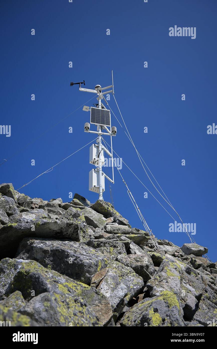 Automatisierte Wetterstation, die meteorologische Daten auf abgelegenen Berggipfeln sammelt, angetrieben von Sonnenenergie. Stockfoto