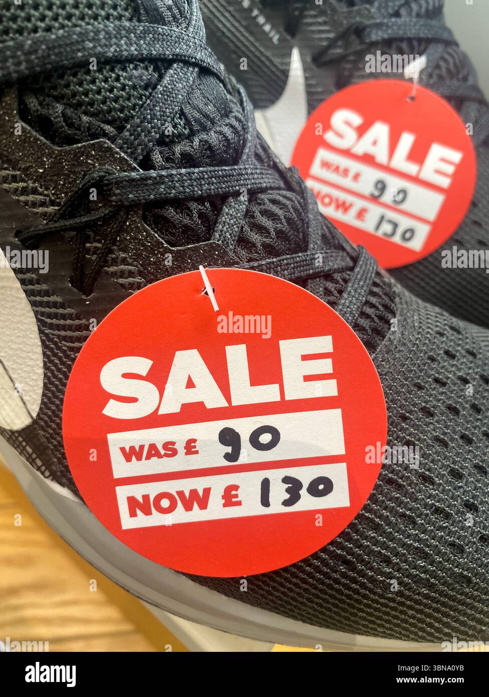 Ein Paar Schuhe, die in einem Geschäft verkauft werden, aber das Preisetikett wurde falsch gekennzeichnet - Smartphone-aufgenommenes Stockfoto