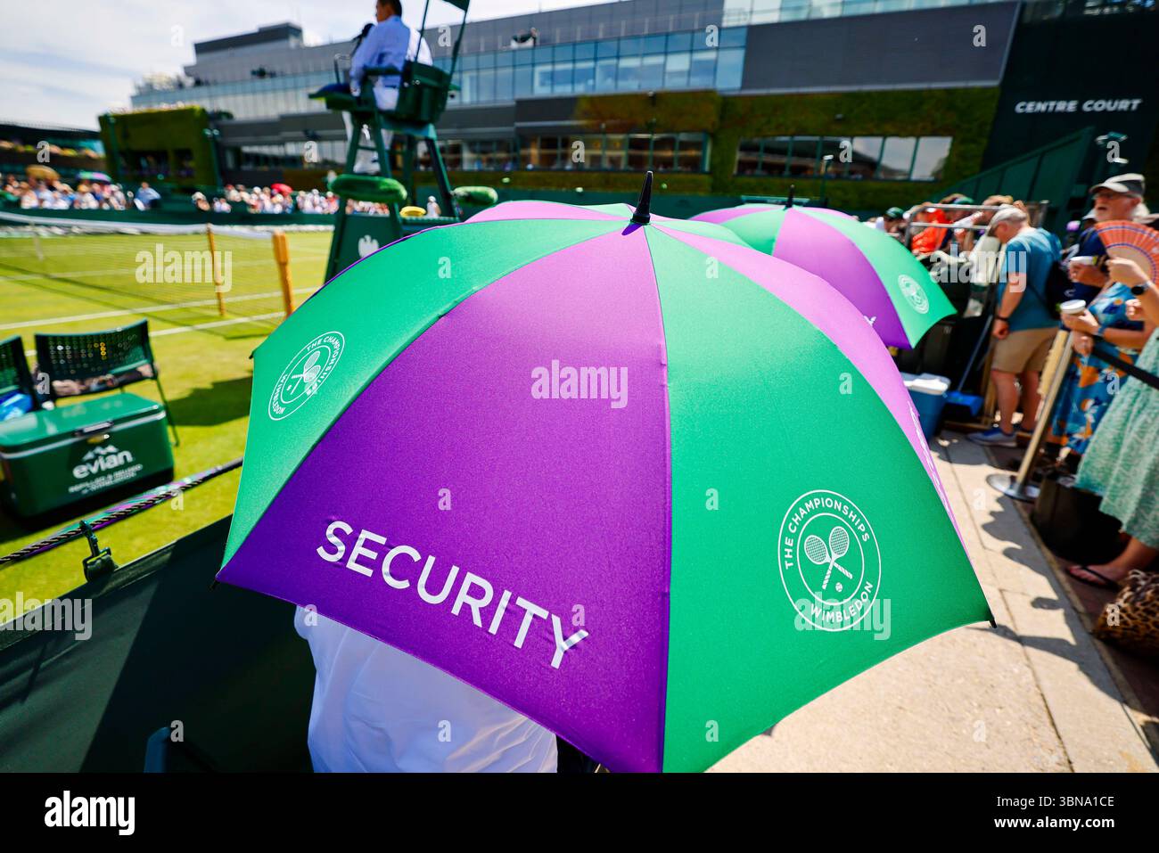 London, Großbritannien. Juli 2025. Tennis: Grand Slam/WTA Tour/ATP Tour, Wimbledon. Das Sicherheitspersonal schützt sich mit Sonnenschirmen vor der Sonne. Frank Molter/dpa/Alamy Live News Stockfoto