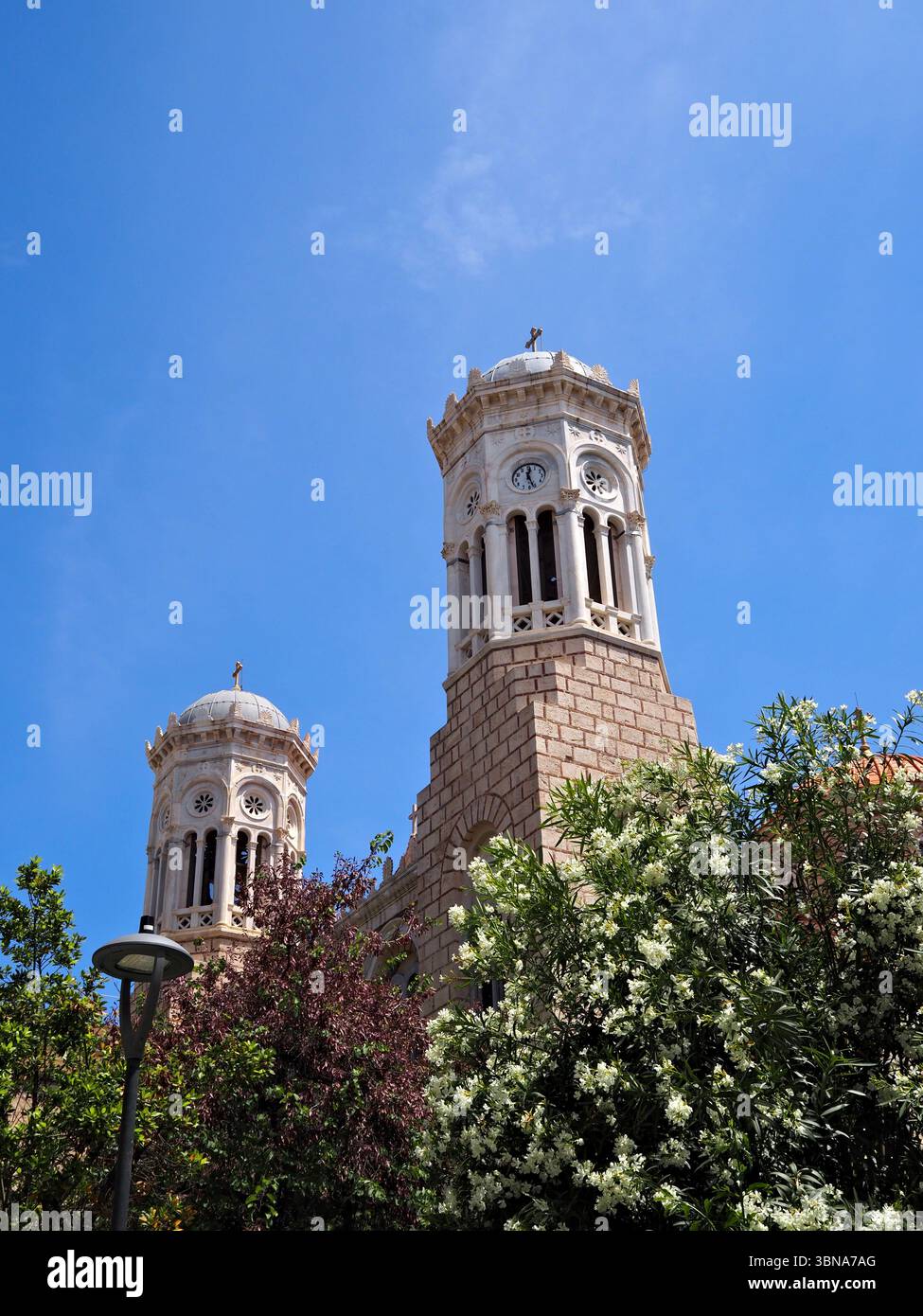 Griechisch-orthodoxe Kirche in Athen mit Turm und Grün unter einem hellblauen Himmel. Stockfoto