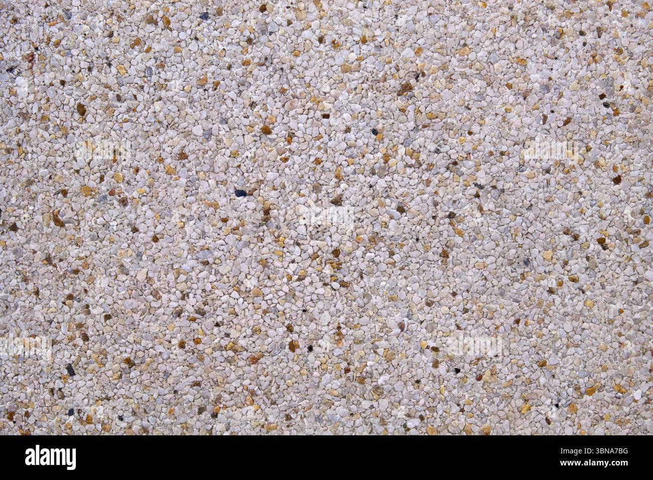 Hellgrauer Sichtbeton in Nahaufnahme - Muster mit einigen braunen Steinen Stockfoto