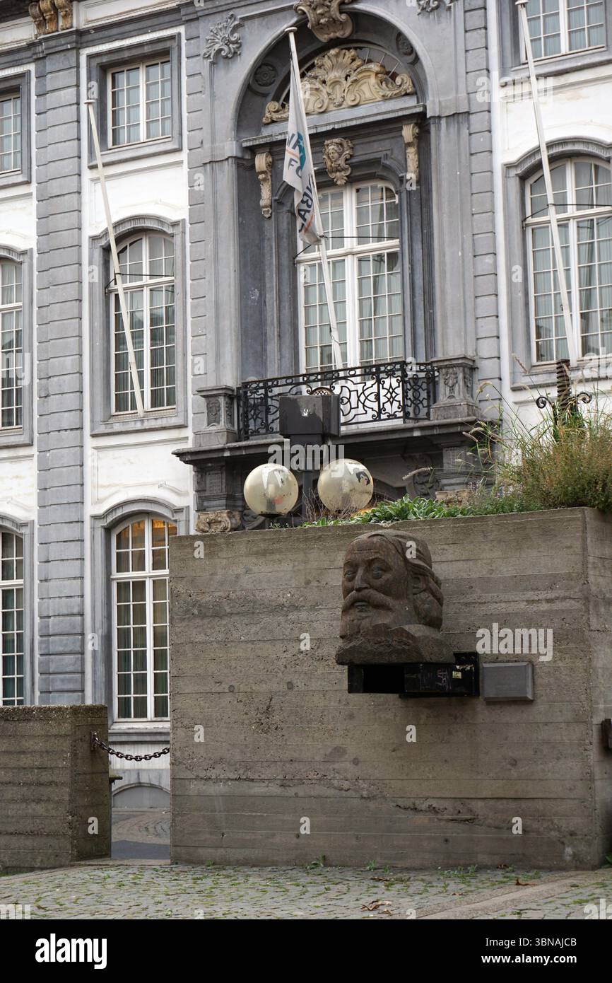 Ein graues Steingebäude mit weißen Zierleisten und einem schwarzen schmiedeeisernen Balkon. Auf dem Balkon ist ein Fahnenmast mit einer weißen Flagge mit den Buchstaben „AR“ zu sehen. Das Gebäude verfügt über mehrere Fenster mit weißen Rahmen und einen dekorativen Bogen über dem Balkon. Vor dem Gebäude befindet sich eine Betonmauer mit einer Steinskulptur des Kopfes eines Mannes. Zwei große, runde, weiße Objekte sind an der Wand montiert, und ein kleines, dunkles Objekt ist an der Wand in der Nähe der Skulptur angebracht. Das Grundstück vor dem Gebäude ist mit Kopfsteinpflaster gepflastert. Antwerpen, zweitgrößte belgische Stadt, liegt an der S Stockfoto