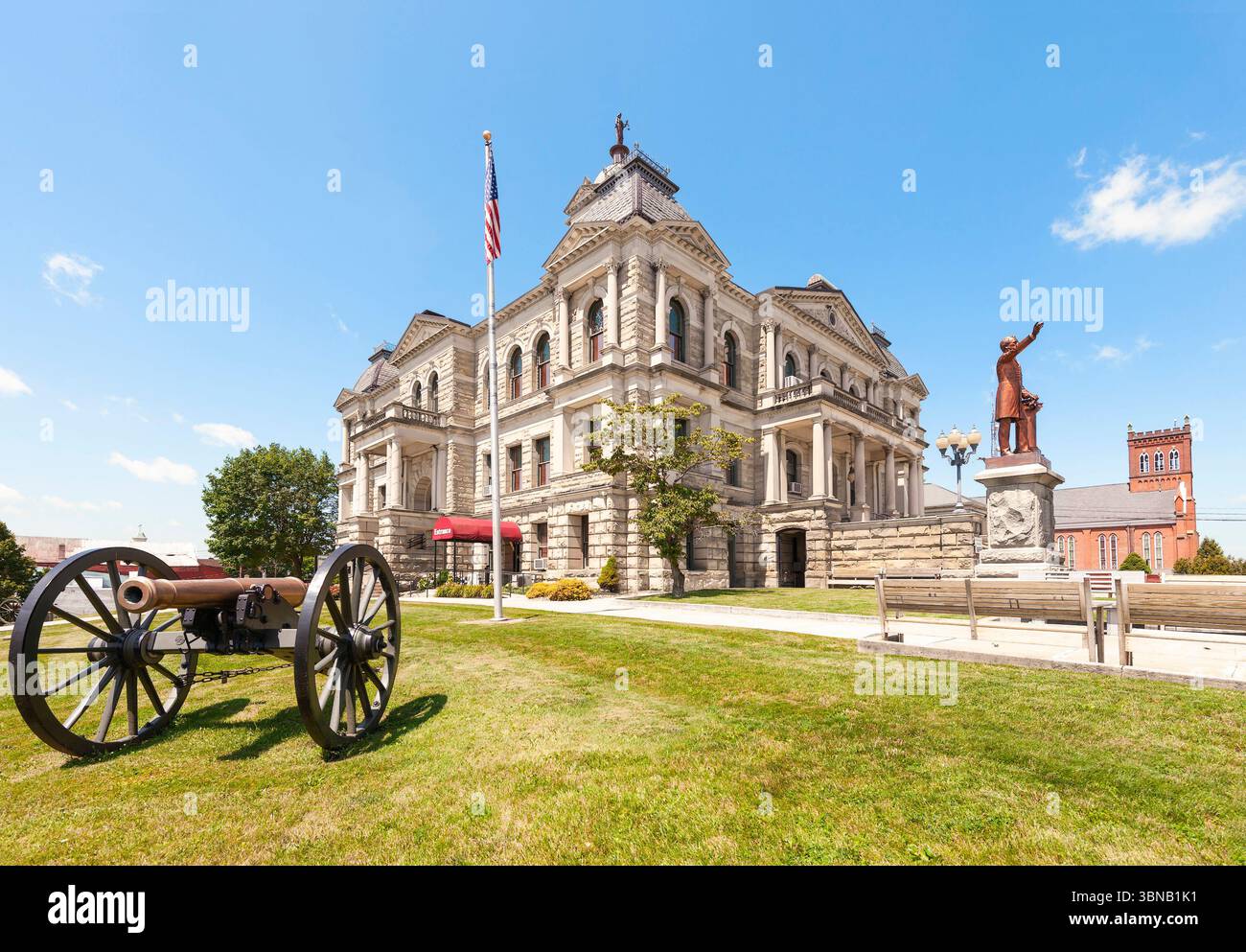 Cadiz. Ohio. USA - 22. Juni 2025 - das Harrison County Courthouse aus dem 19. Jahrhundert. Die Bronzestatue von John Bingham befindet sich auf der rechten Seite Stockfoto