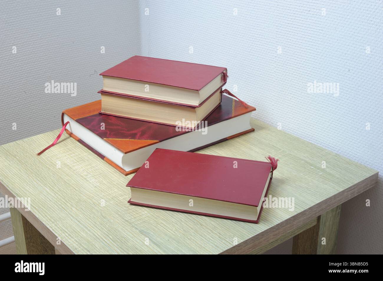 Stapel Bücher auf einem Tisch in einem Gästezimmer Stockfoto