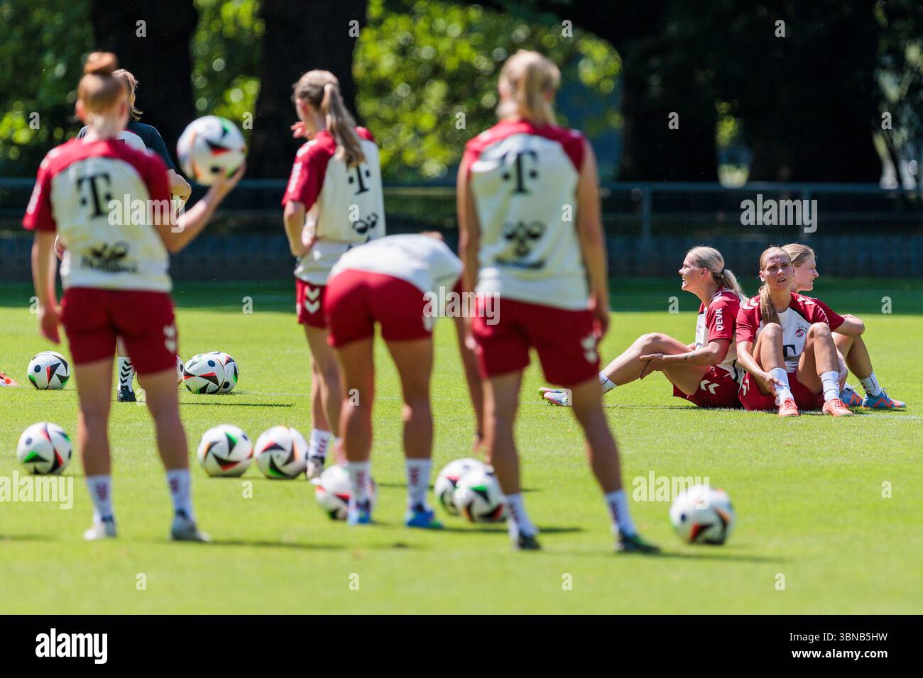 Julia Schiffarth (1. FC K?ln, 22), Merle Hokamp (1. FC K?ln, 13) und Taylor Ziemer (1. FC K?ln, 18) sitzen auf dem Boden und warten auf ihre Mitspielerinnen beim Trainigsauftakt der 1. FC K?ln Frauen am 01.07.2025 am GEI?bockheim in K?ln Stockfoto