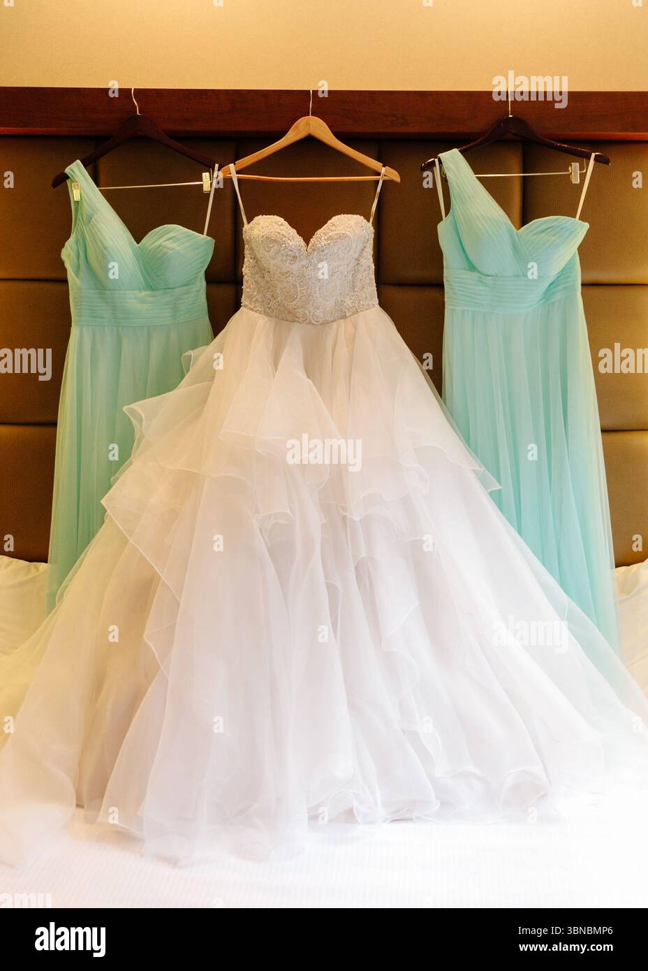 Wunderschöne Hochzeitskleider für die Braut und die Brautjungfern in einer luxuriösen Hochzeitssuite, die gespannt auf den großen Tag wartet. Stockfoto