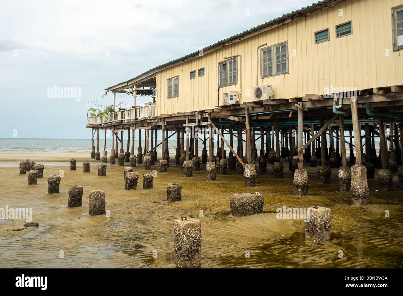 City Beach, Holzbau des Restaurants auf Stelzen, Pier, Hua hin Resort, verfallene Betonsäulen, Thailand Stockfoto