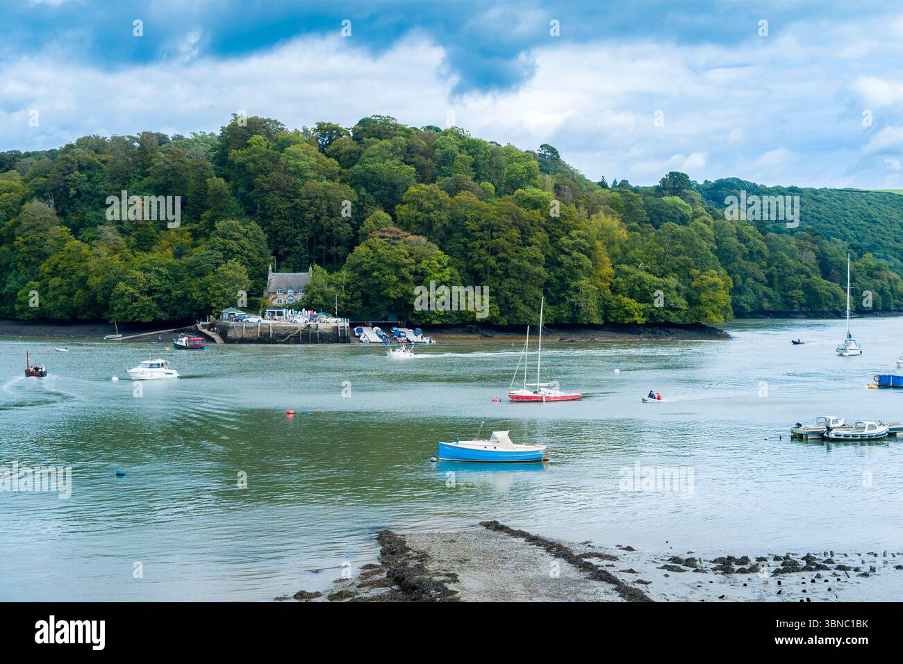 Fischerboote und Freizeitboote vor Anker in einer ruhigen Szene am Ufer des Flusses Dart in Devon, England, Großbritannien Stockfoto