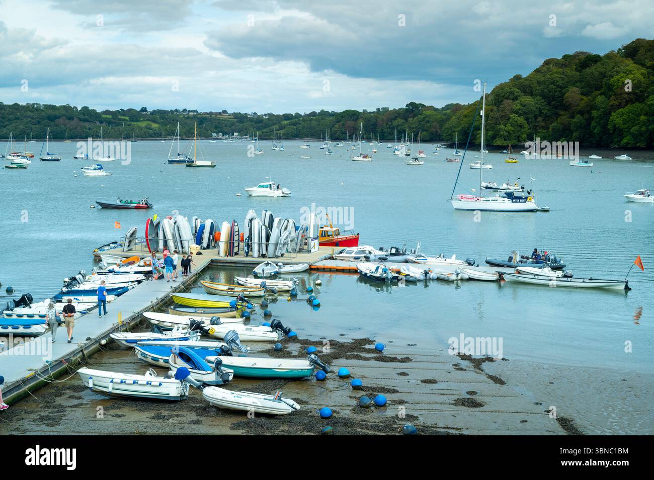 Fischerboote und Freizeitboote vor Anker in ruhigen Gewässern bei Ebbe am Ufer in einer ruhigen Szene am Fluss Dart in Devon, England, United Stockfoto