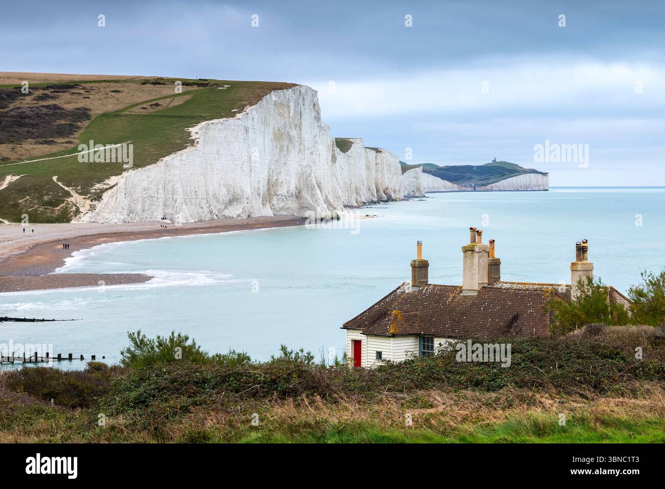Cottages der Küstenwache überblicken weiße Kreide Seven Sisters Cliffs und Cuckmere Haven Beach an der Mündung des Cuckmere River bei Seaford in East Sussex Stockfoto