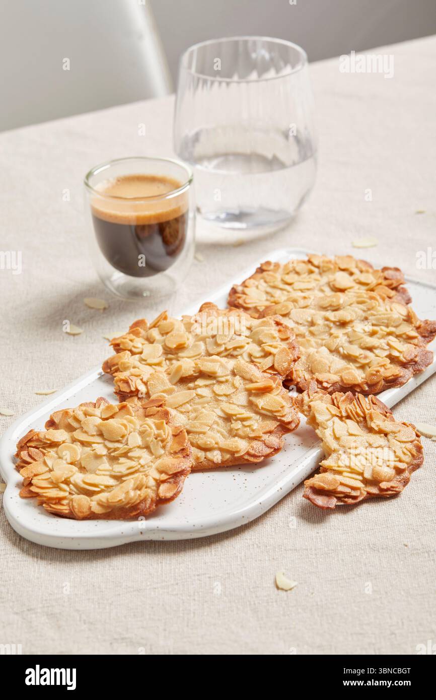 Delikater veganer Dessert Tuile (hippe) – ein knuspriger und eleganter süßer Kaffee, serviert mit einem kleinen Espresso, perfekt als leichtes Finale für Menüs oder Kaffeepausen. Stockfoto