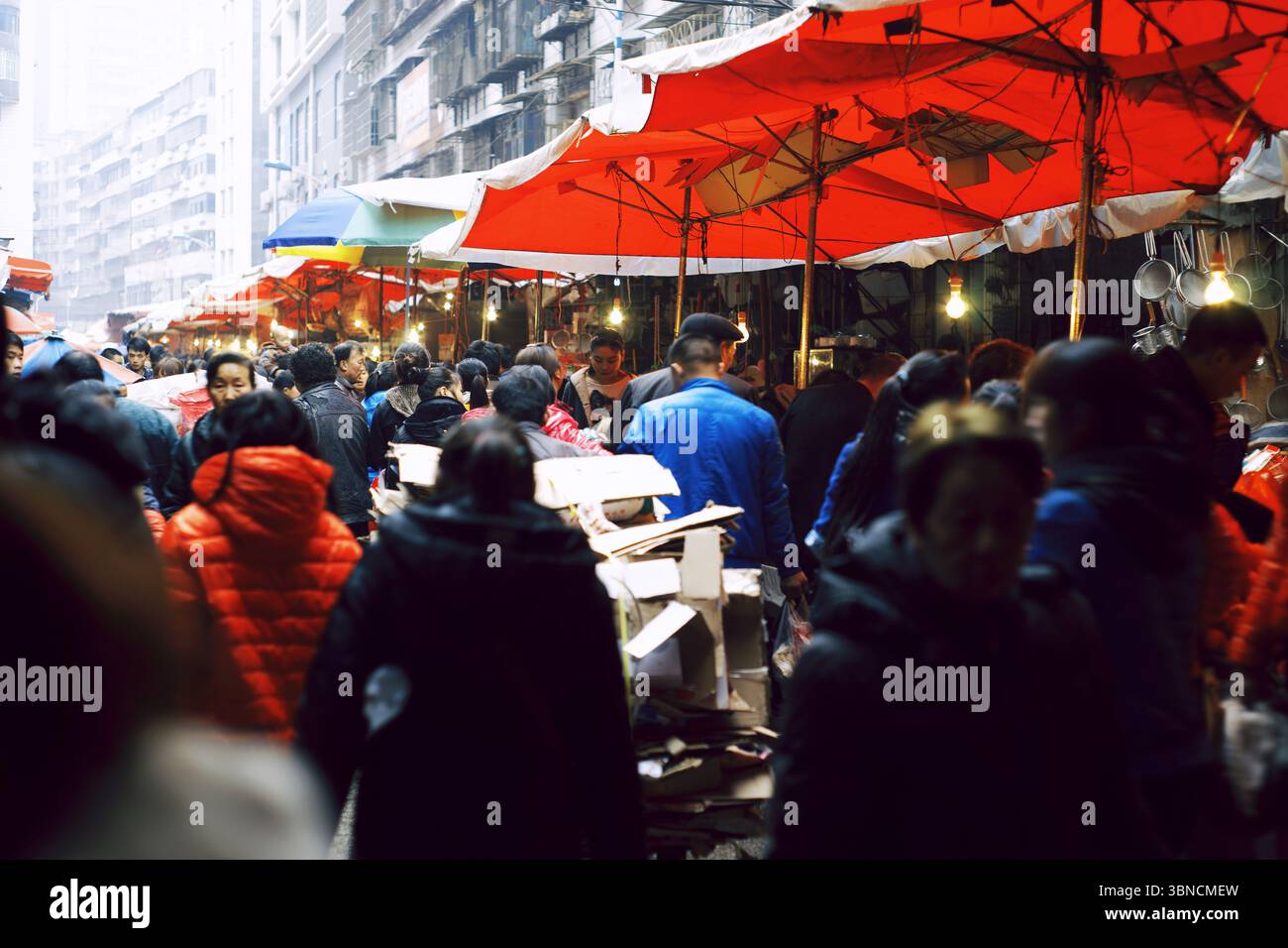 Überfüllter Straßenmarkt unter roten Schirmen in Duyun, Guizhou Stockfoto