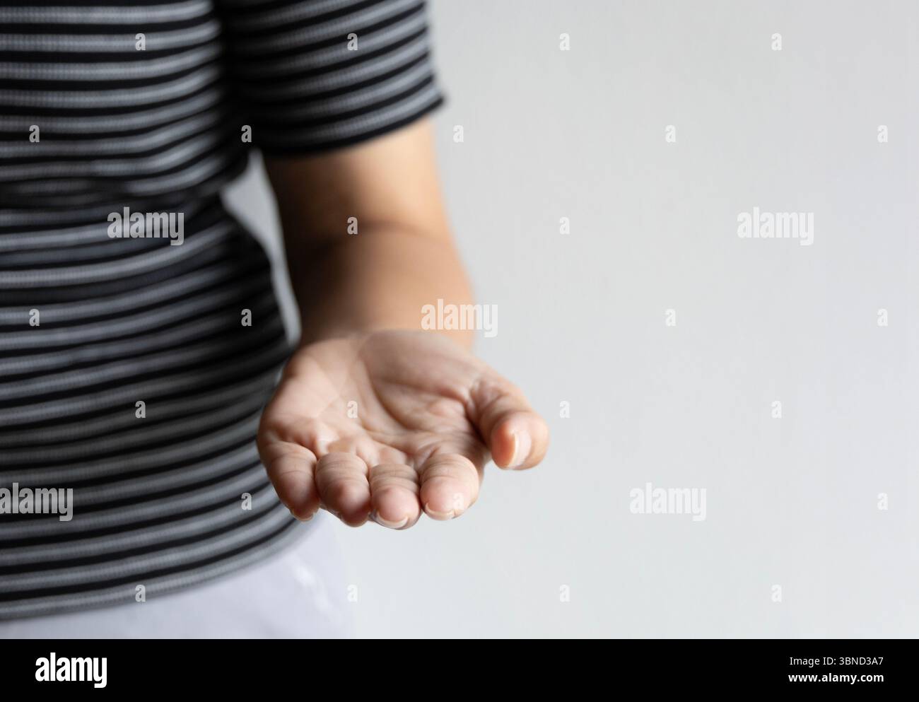Isolierte Frau Hand offene Handfläche entspannte Finger weicher heller weißer Hintergrund sanfte Geste Einladung symbolisiert menschliche Interaktion ruhige Berührung natürlich Stockfoto