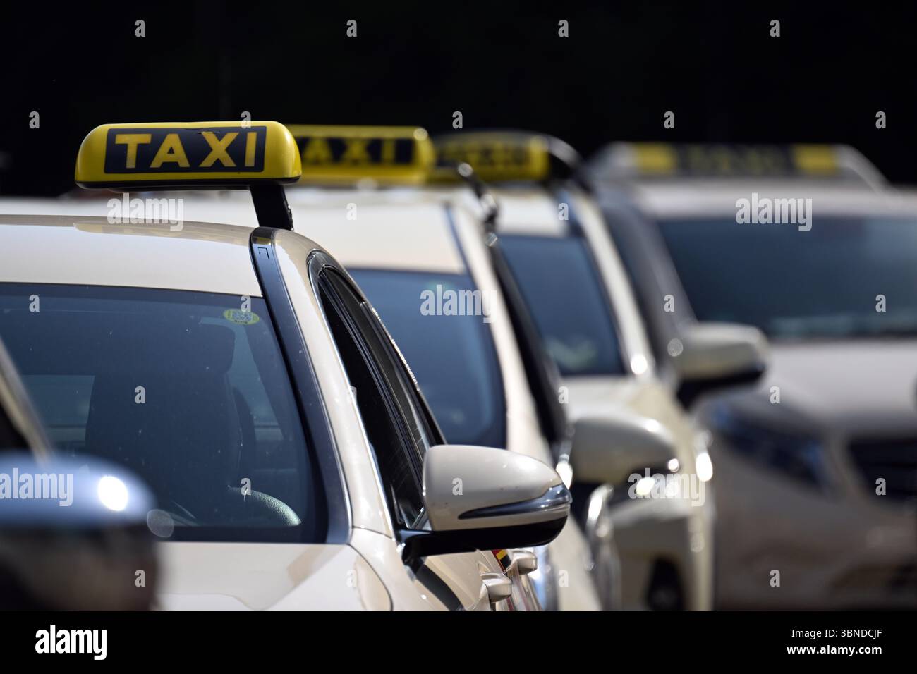 Düsseldorf, Deutschland. Juli 2025. Taxis stehen auf einem Messeparkplatz, um sich für eine Autokolonne zu versammeln. Die Taxiindustrie hält heute einen landesweiten Protesttag ab. Die Industrie fordert die lokalen Behörden auf, Mindestgebühren für Mietwagen wie Uber und Bolt festzulegen, wie sie es auch für den Taxihandel tun. Quelle: Federico Gambarini/dpa/Alamy Live News Stockfoto
