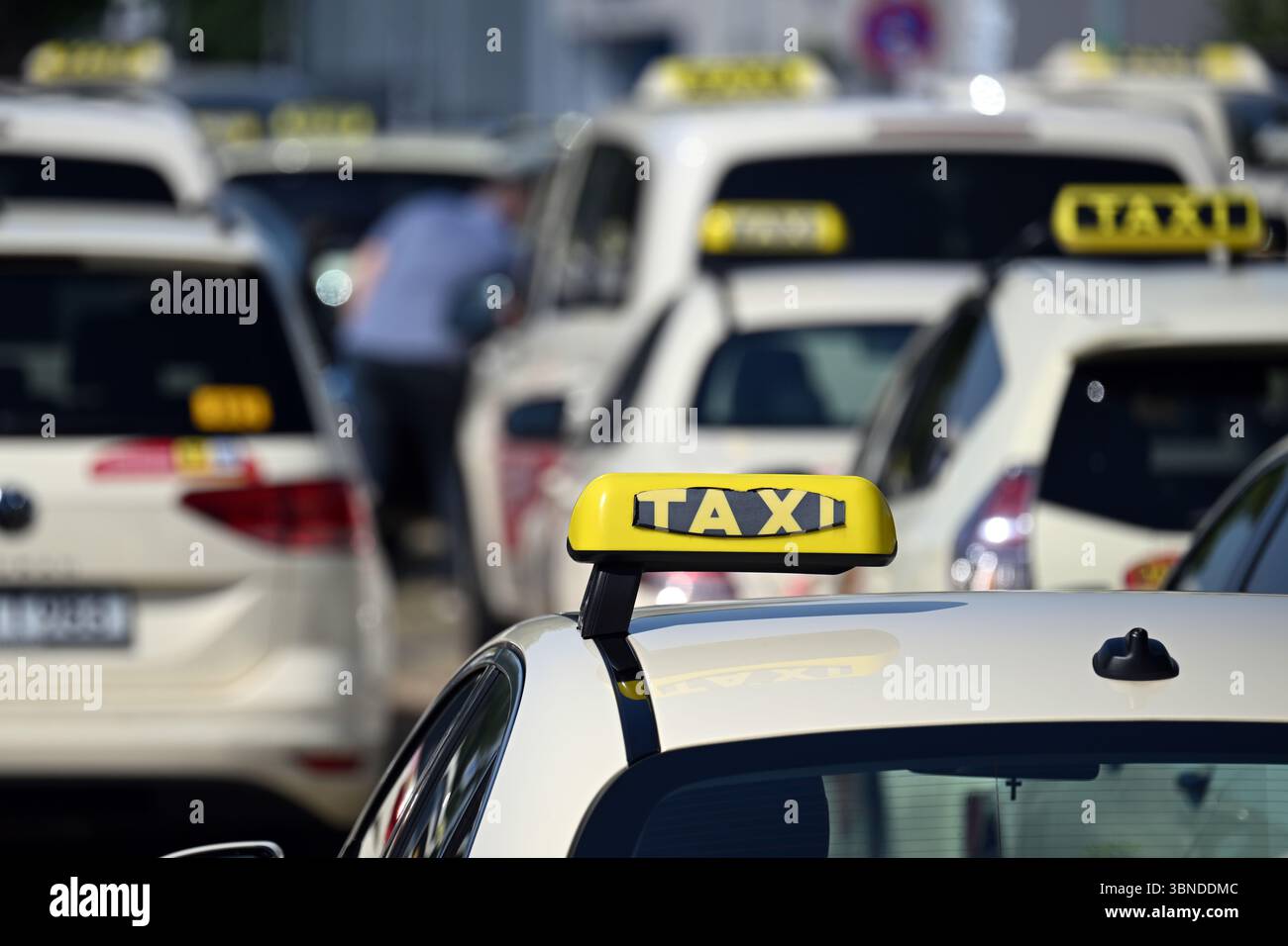 Düsseldorf, Deutschland. Juli 2025. Taxis stehen auf einem Messeparkplatz, um sich für eine Autokolonne zu versammeln. Die Taxiindustrie hält heute einen landesweiten Protesttag ab. Die Industrie fordert die lokalen Behörden auf, Mindestgebühren für Mietwagen wie Uber und Bolt festzulegen, wie sie es auch für den Taxihandel tun. Quelle: Federico Gambarini/dpa/Alamy Live News Stockfoto