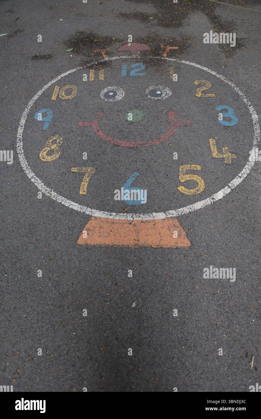 Auf Rollfeld gemalt auf der Uhr des Kinderspielplatzes, die die Zeit angibt, die die Zeit zu erzählen lernt Stockfoto