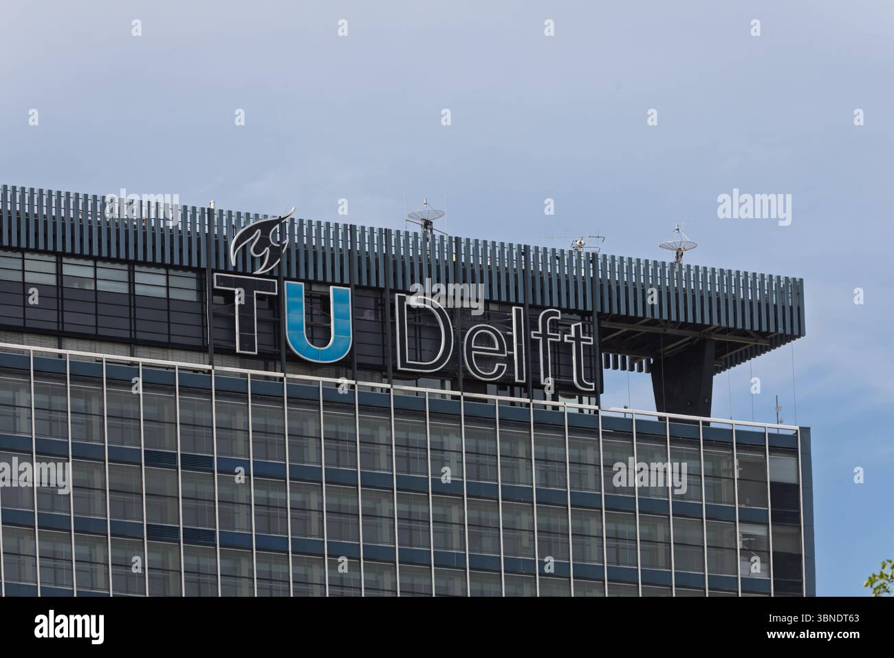 Das prominente Schild „TU Delft“ auf einem modernen Universitätsgebäude symbolisiert akademische Exzellenz und technologische Innovation. Delft, Niederlande, 31 Stockfoto