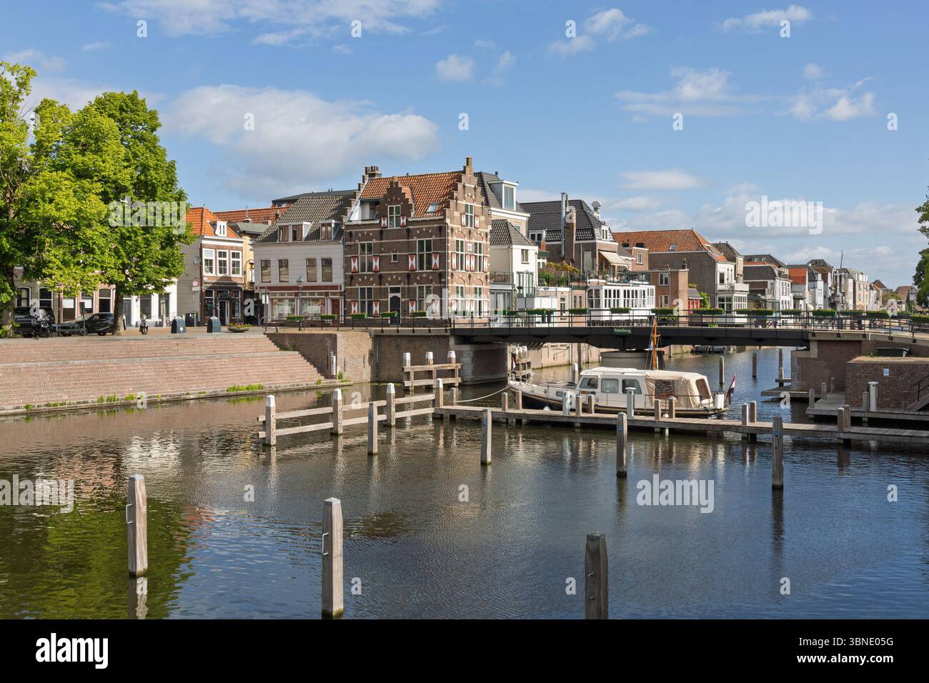 Eine malerische Szene in Gorinchem, Niederlande, mit traditionellen niederländischen Kanalhäusern, der Peterbrug (Peter-Brücke) und einem Hausboot auf der Tranqu Stockfoto