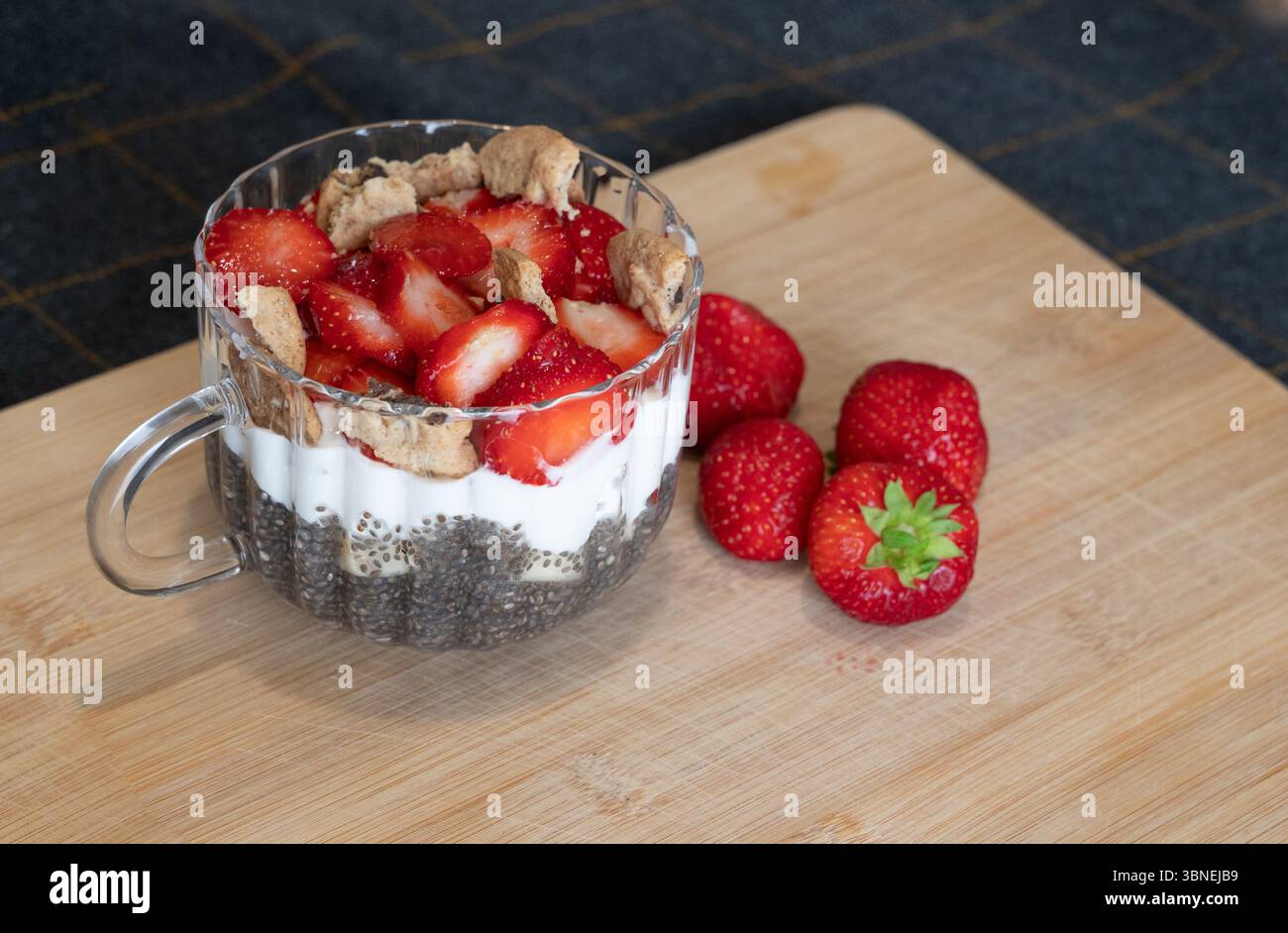 Ein köstliches und köstliches Beerenparfait mit Chiasamen, cremigem Joghurt und knusprigem Topping zum Genießen Stockfoto