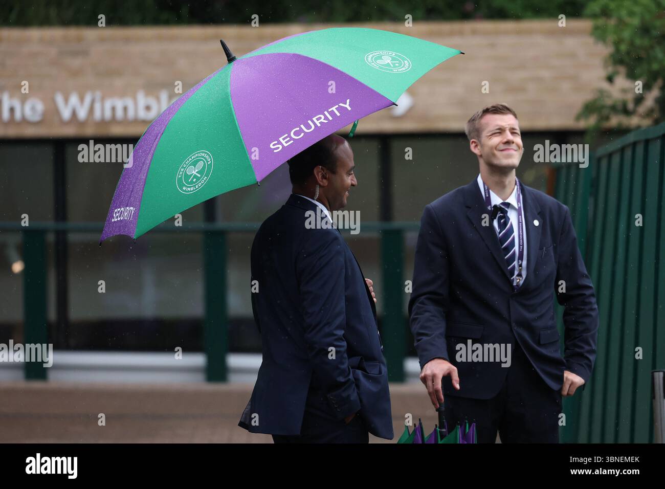Juli 2025; All England Lawn Tennis and Croquet Club, London, England; Wimbledon Tennis Tournament, Tag 3; Wimbledon Security überprüft das Wetter unter einem Wimbledon Regenschirm, während am dritten Tag der Wimbledon Championships heftiger Regen ausströmt. Credit: Action Plus Sports Images/Alamy Live News Stockfoto