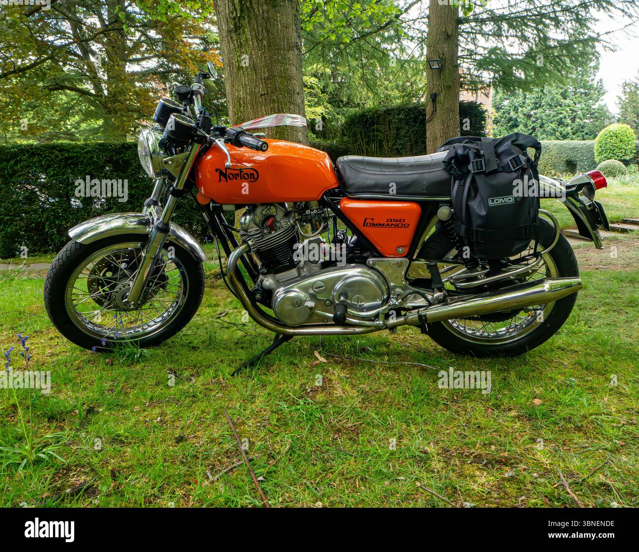 Ein klassisches Norton 750 Commando-Motorrad aus den 1970er Jahren unter Reifen Bäumen in ländlicher Umgebung Stockfoto