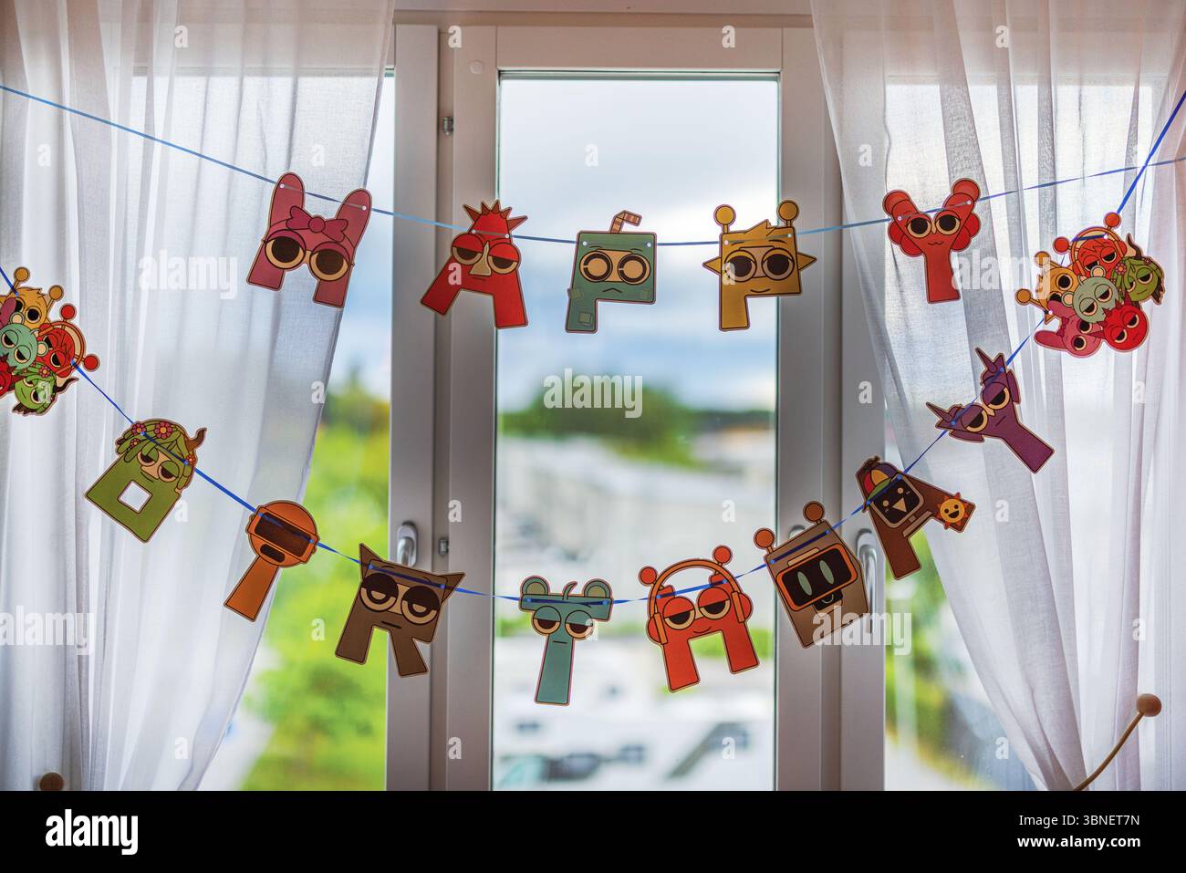Lustiges Cartoon-Banner „Happy Birthday“ hängt am Vorhang in einem gemütlichen Kinderzimmer. Schweden. Stockfoto