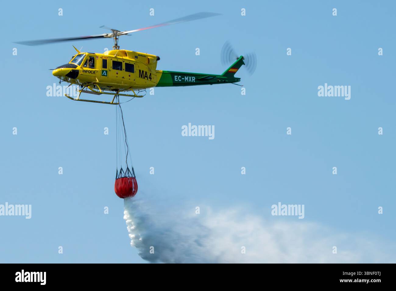 Bell 212 HP Anti-Aufstand-Hubschrauber beim Motril Air Festival mit dem Bambi gefüllt mit Wasser. Stockfoto