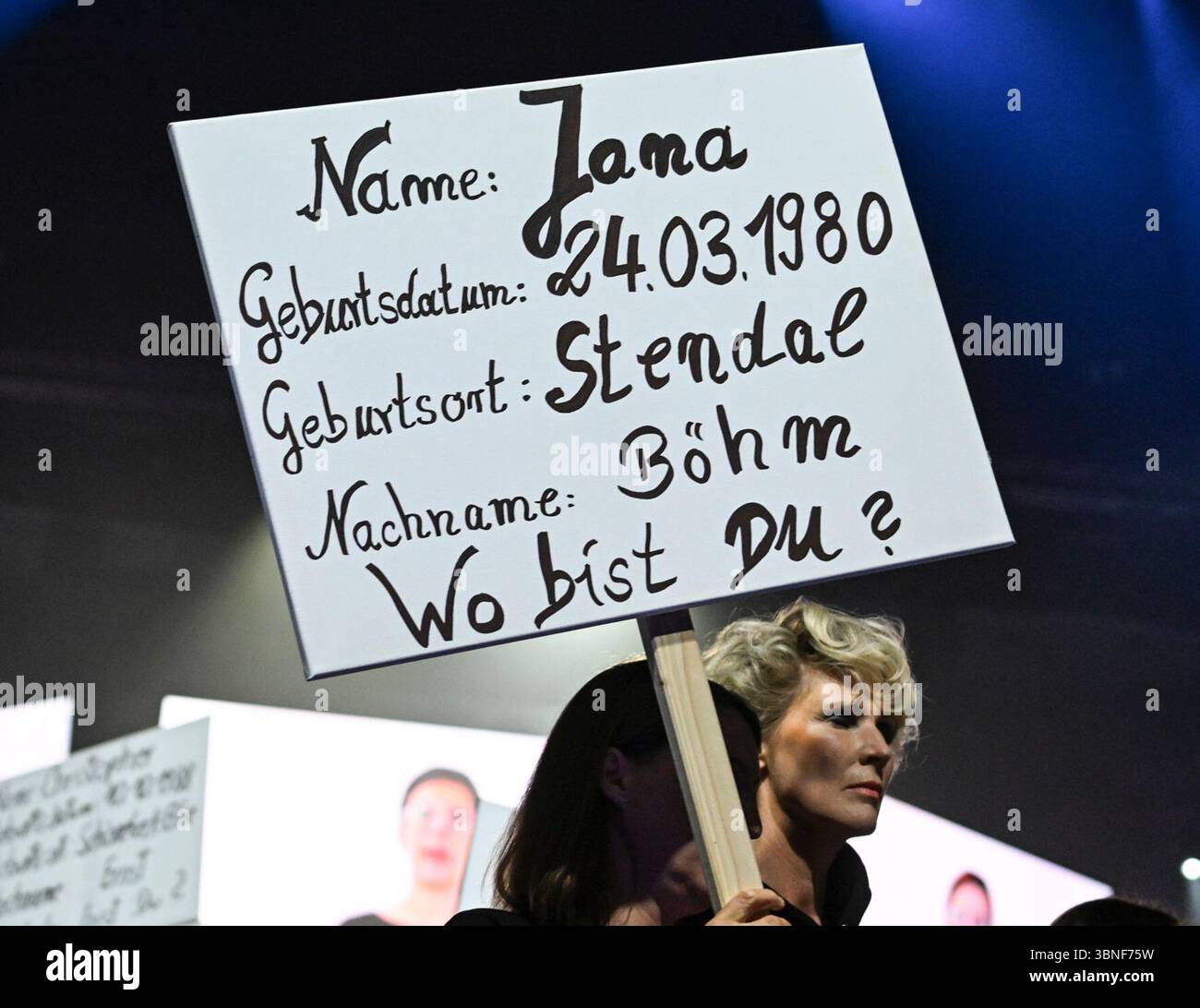 Berlin, Deutschland. Juli 2025. Als Teil der Show von Designer Kilian Kerner auf der Modeschau 'DDR. Die gestohlenen Kinder für Frühjahr/Sommer 2026 im Collevtivefour Space in der Uber Arena zeigen Models und Mitarbeiter Plakate zum Thema. Quelle: Jens Kalaene/dpa/Alamy Live News Stockfoto