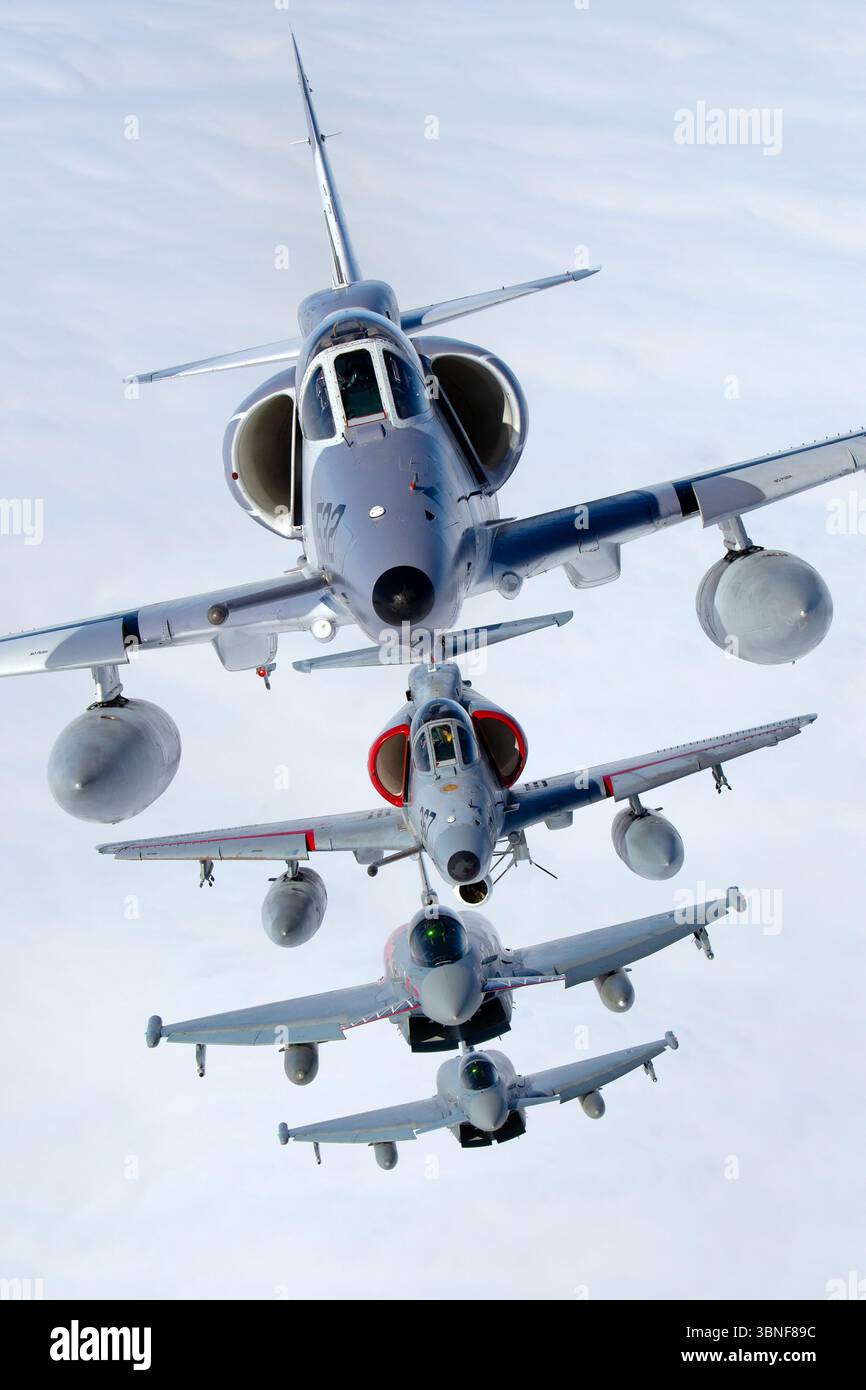 Zwei deutsche Luftwaffe-Eurofighter EF‑2000 Typhoon S, Hecknummern 30+90 und 30+33, fliegen in gemischter Vierschiffenformation mit den Top Aces McDonnell Douglas A‑4N Skyhawk II-Flugzeugen C‑FGZO (Code 532) und C‑FGZD (Code 367) nahe Wittmundhafen. Die Taifune tragen hundertjährige Staffelfarbe, während die Skyhawks während dieser Air-to-Air-Aktion gegnerische Trainingsfarben zeigen. Stockfoto