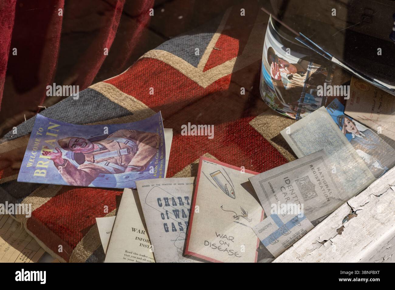 Erinnerungsstücke aus dem Zweiten Weltkrieg, darunter Flugblätter aus Kriegszeiten und Propagandakataloge, die in einem Schaufenster im Vintage-Stil in der Altstadt von Bridlington ausgestellt werden. Stockfoto