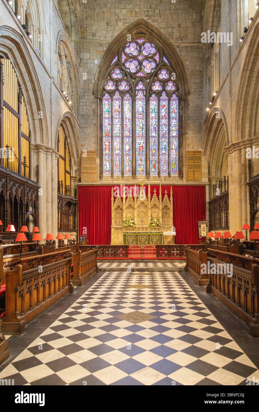 Das Schiff der Bridlington Priory mit dem Buntglasfenster im Osten, mit großen Bögen und Steinsäulen, die das mittelalterliche Kircheninnere umrahmen. Stockfoto