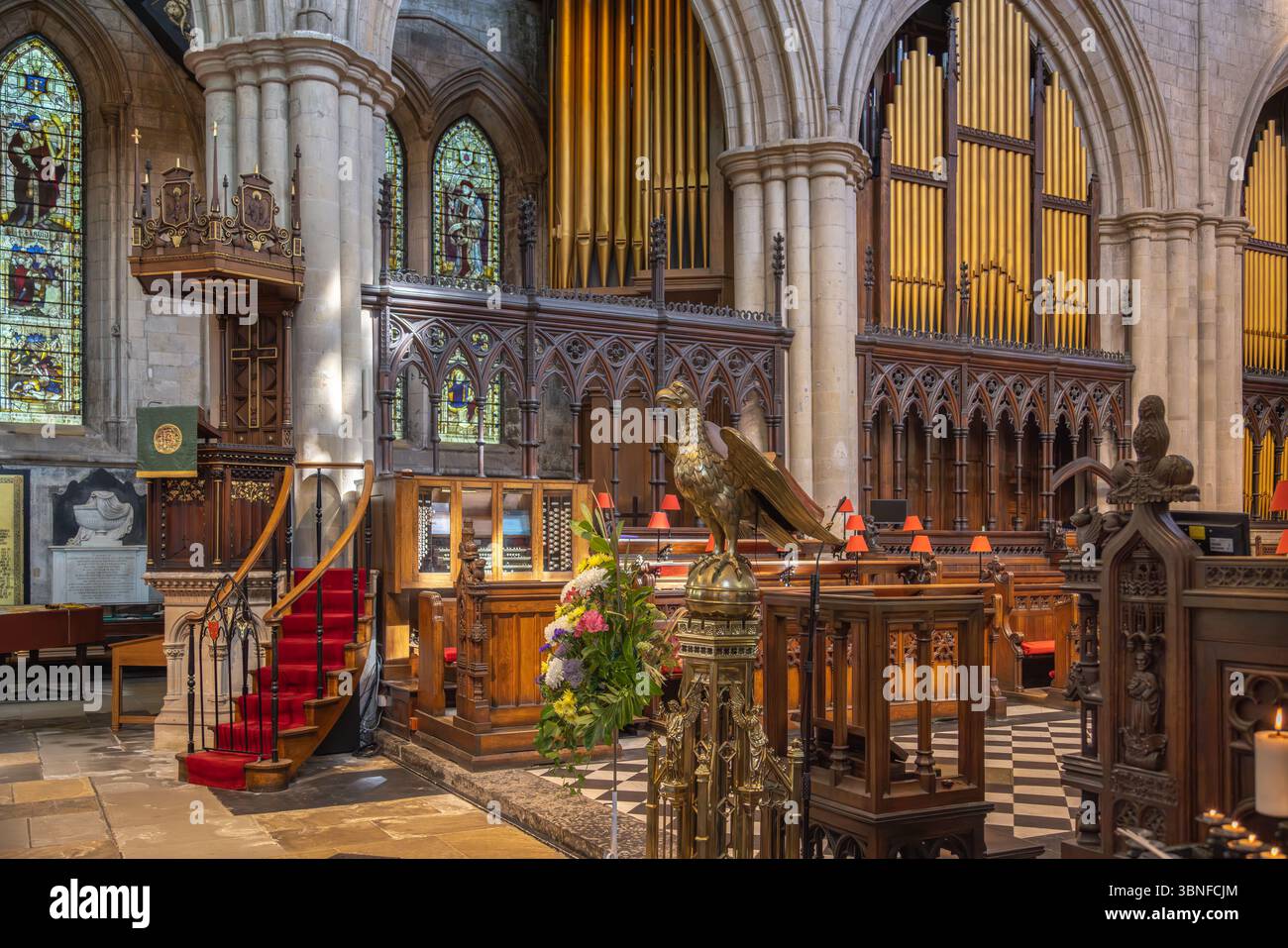 Innenraum der Bridlington Priory in Yorkshire mit geschnitzter Kanzel, Messingpult, Pfeifenorgel und Buntglasfenstern innerhalb der historischen Kirche Stockfoto