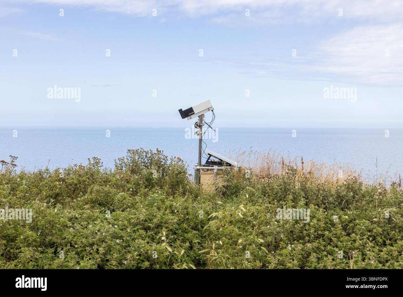Eine Überwachungskamera beobachtet offene See und leeres Land. Eine deutliche Erinnerung daran, dass man selbst in der Natur nie allein ist. Das Konzept, beobachtet zu werden. Stockfoto
